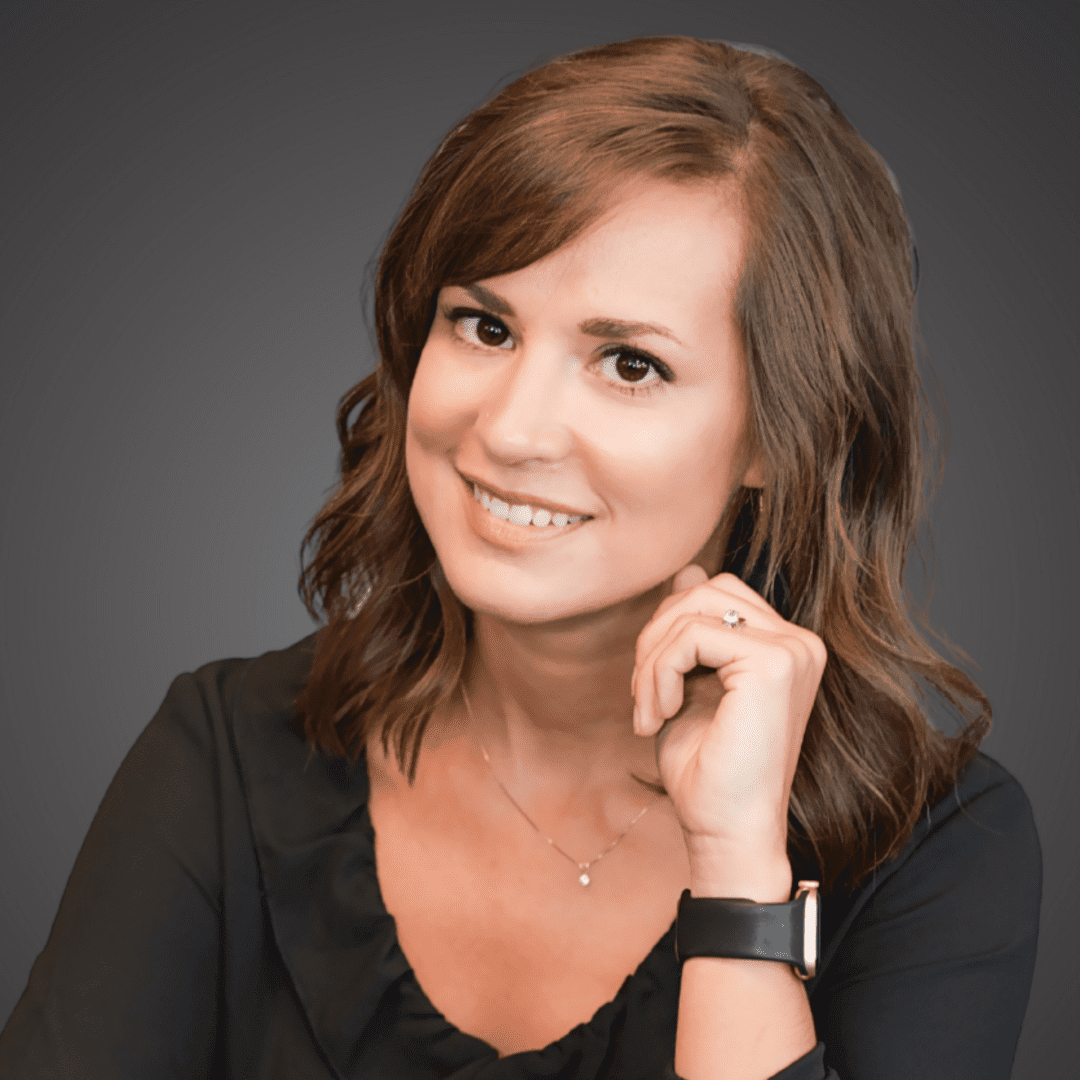 Smiling woman with wavy brown hair in black top.