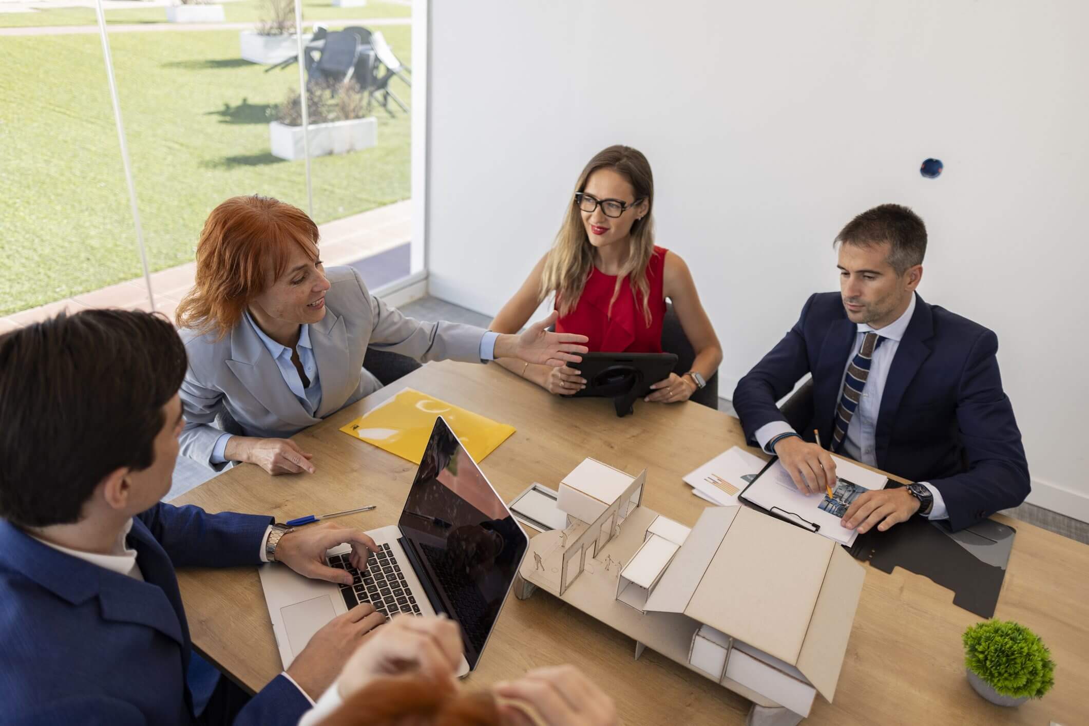 Business meeting with five people at table.