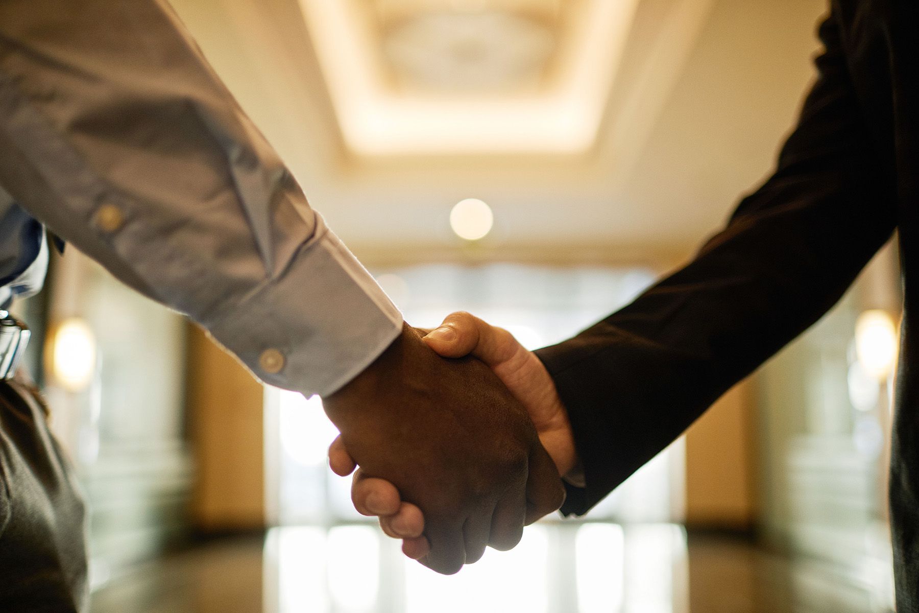Two people shaking hands in a professional setting.
